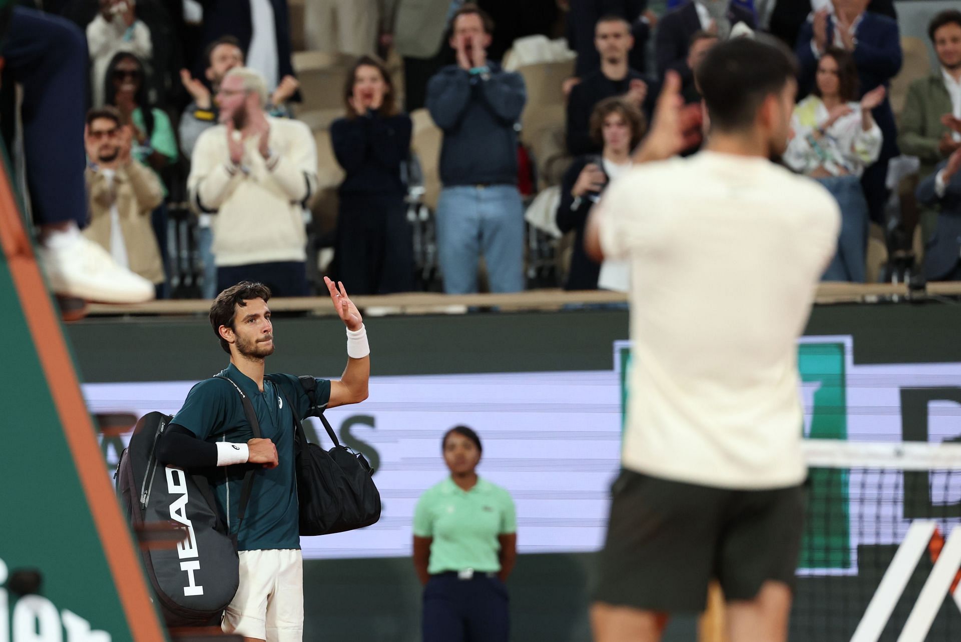 Carlos Alcaraz shows respect as Lorenzo Musetti retires at the 2025 French Open - Image Source: Getty